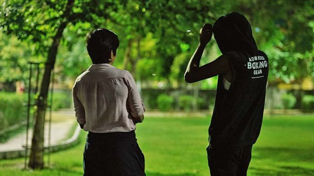 Jornalista da BBC junto ao entrevistado, ambos de costas para a câmera